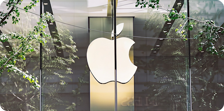 Podświetlone logo Apple na szklanej fasadzie budynku