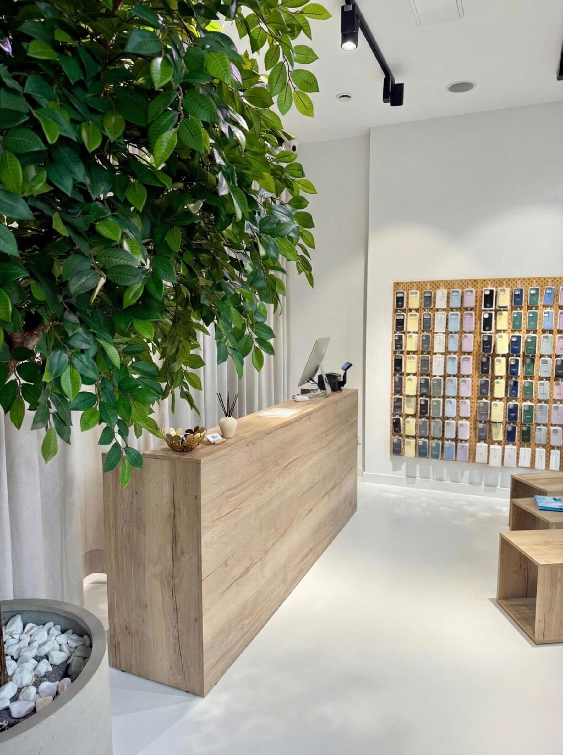 Wnętrze serwisu Apple Flix z ladą obsługi i ekspozycją etui na iPhone