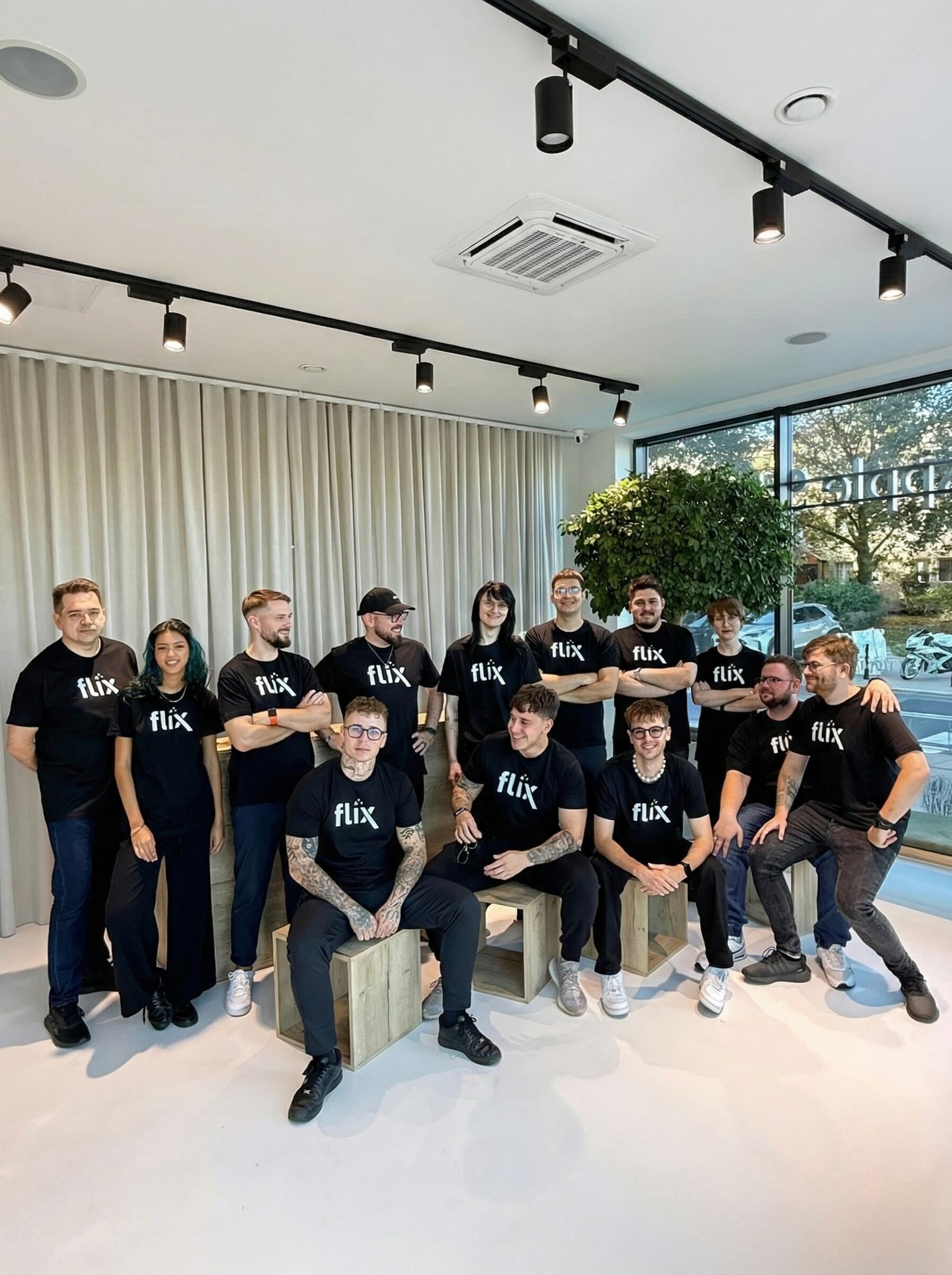 Zespół serwisantów Apple Flix w firmowych koszulkach w salonie napraw